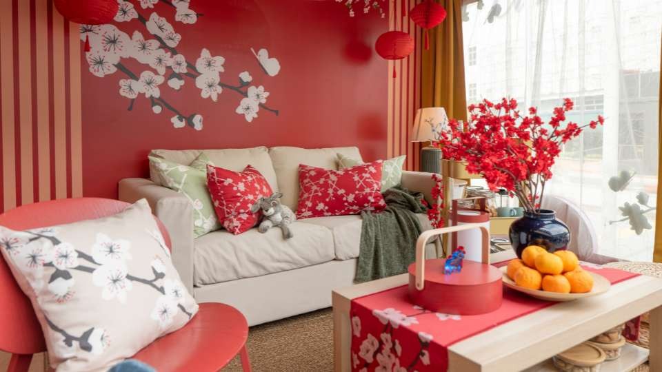 Gối sofa với họa tiết nổi bật kết hợp bình hoa đỏ trên bàn trà