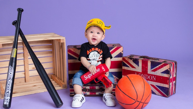 Hình ảnh em bé trai đang chơi đùa vui vẻ thể hiện sự hồn nhiên và đầy sức sống của tuổi thơ