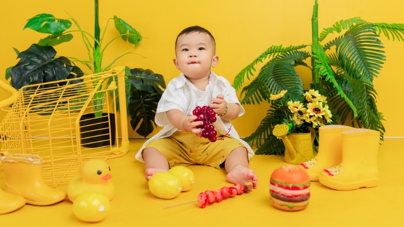 Hình ảnh em bé trai đang chơi đùa vui vẻ thể hiện sự hồn nhiên và đầy sức sống của tuổi thơ