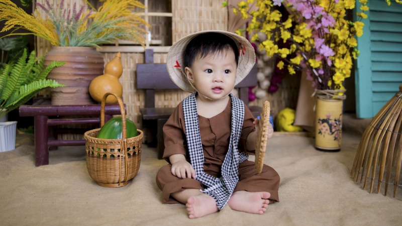 Hình ảnh em bé trai đang chơi đùa vui vẻ thể hiện sự hồn nhiên và đầy sức sống của tuổi thơ